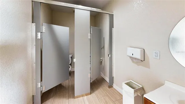 a area with wooden floor and a bathroom