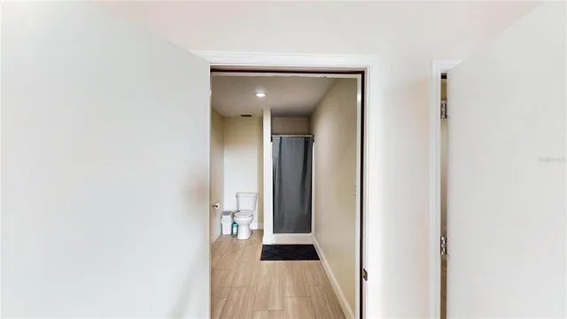 a view of a hallway with wooden floor