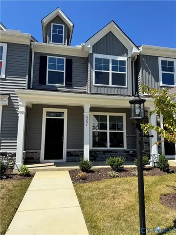 a view of a house with small yard plants and a table and chairs in porch