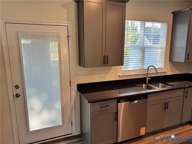 a room with kitchen island granite countertop wooden floors a stove and kitchen island