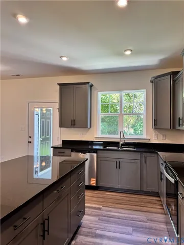 a kitchen with granite countertop a sink and wooden cabinets