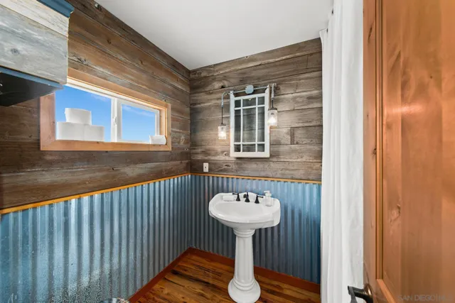 a bedroom with a bed and a dresser next to a window