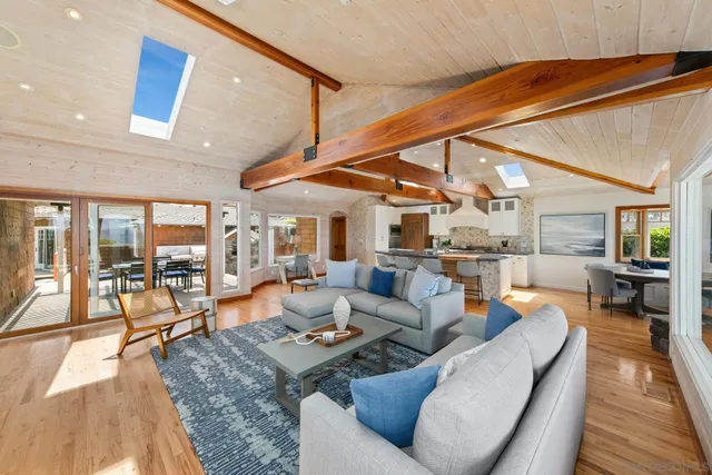 a living room with stainless steel appliances kitchen island granite countertop furniture and a large window