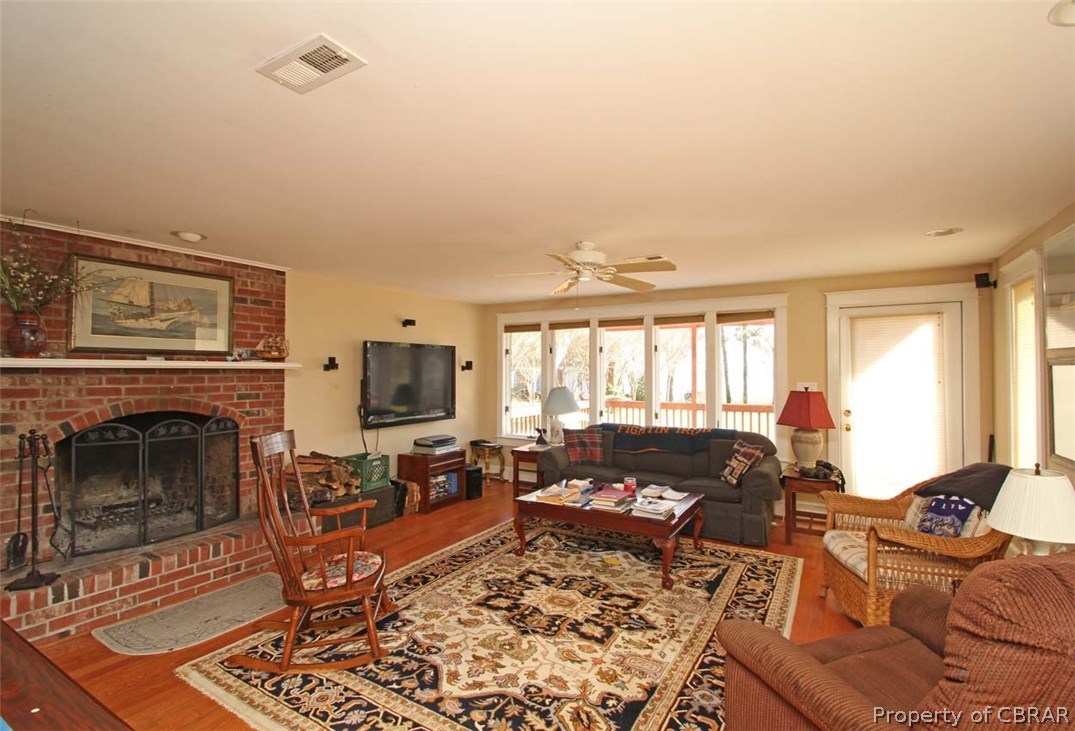 3974 Weems Road Weems, VA 22576 - Photo 14 of 37 Part of the large River Room with large wood burning fireplace & french door leading to the deck.
