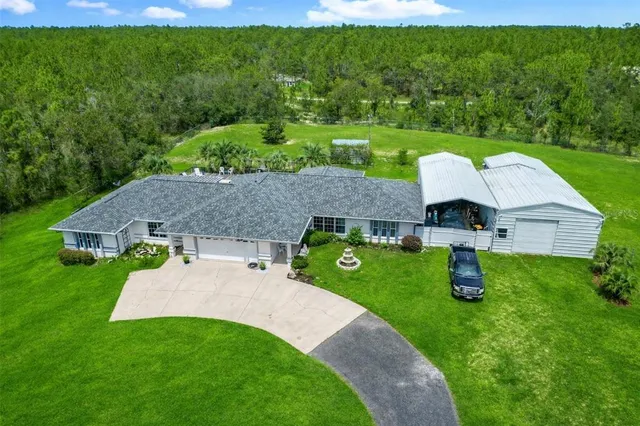 an aerial view of a house with garden space and outdoor seating