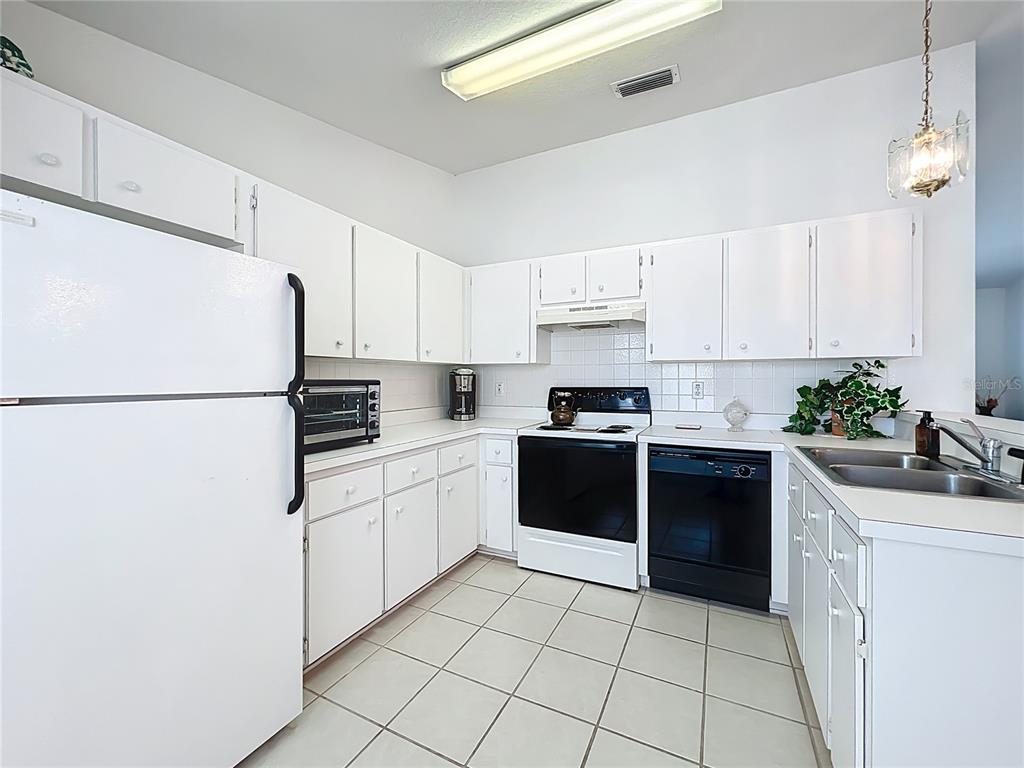 22163 Southwest Edgewater Boulevard Dunnellon, FL 34431 - Photo 50 of 78 a kitchen with a white cabinets and white appliances