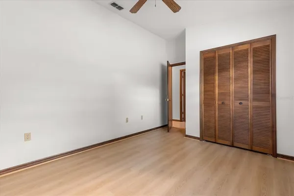 an empty room with ceiling fan and window