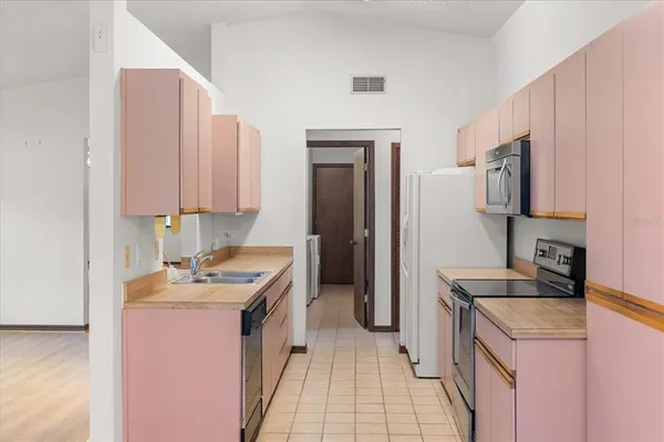 a kitchen with stainless steel appliances white cabinets and a refrigerator