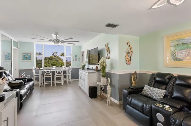 a living room with furniture a ceiling fan and a window