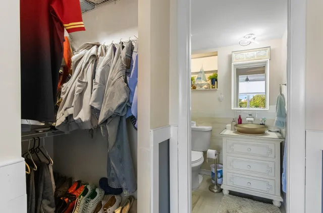a bathroom with a granite countertop sink a toilet and a shower