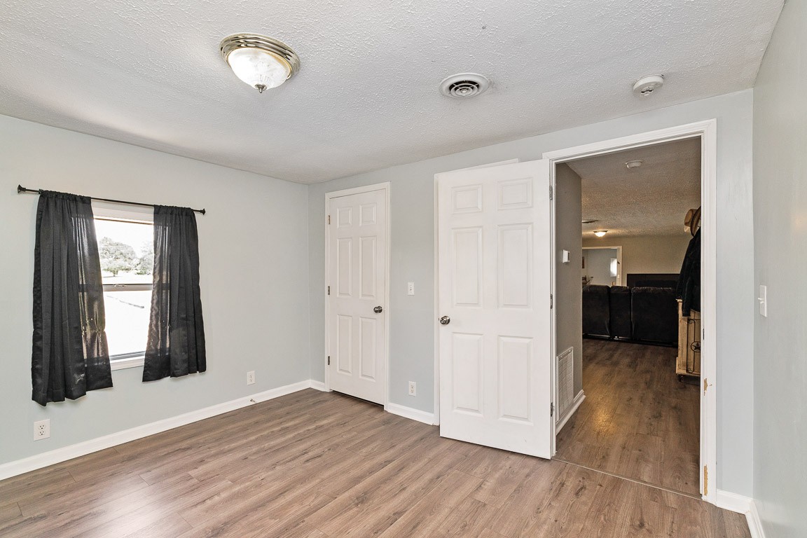 425 Keysburg Road Adams, TN 37010 - Photo 26 of 45 an empty room with wooden floor and windows