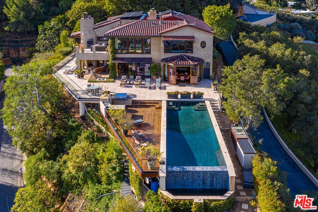 1870 Mango Way Los Angeles, CA 90049 - Photo 2 of 28 a view of a big yard with table and chairs under an umbrella