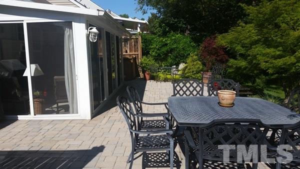 5435 Brandy Bay Road Raleigh, NC 27613 - Photo 20 of 25 Paverstone patio, entry to sunroom, outdoor accent lighting, professionally landscaped, water fountain feature,