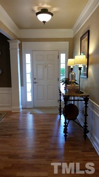 5435 Brandy Bay Road Raleigh, NC 27613 - Photo 8 of 25 Transom windows around the front entry, wainscoting, pillar, custom crown molding