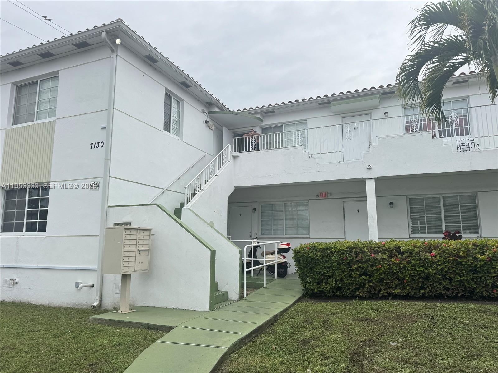 7130 Rue Versailles Drive, Unit 4 Miami Beach, FL 33141 - Photo 3 of 12 a view of a white house with a yard and plants
