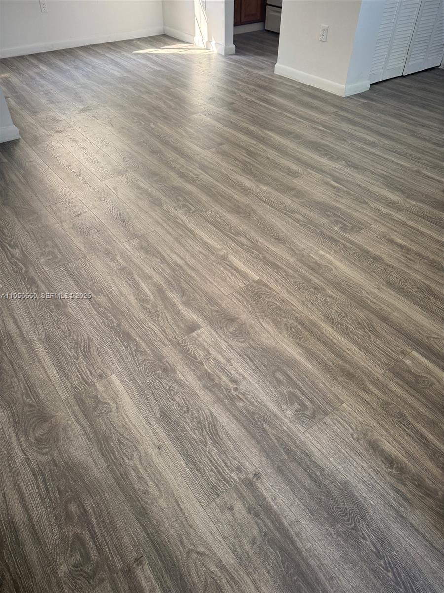 7130 Rue Versailles Drive, Unit 4 Miami Beach, FL 33141 - Photo 5 of 12 an empty room with wooden floor