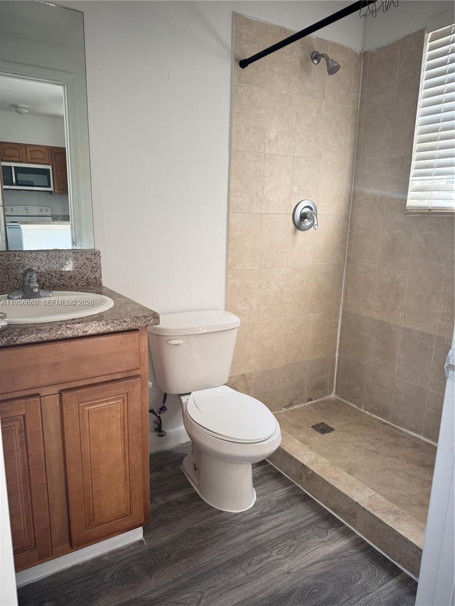 7130 Rue Versailles Drive, Unit 4 Miami Beach, FL 33141 - Photo 6 of 12 a bathroom with a sink a toilet a shower and a mirror