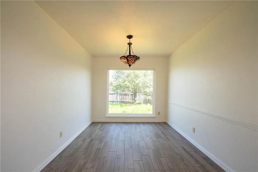 6500 Blue Ridge Trail Plano, TX 75023 - Photo 3 of 14 Spacious interior room with wood-finish flooring, a contemporary chandelier, large window, and crown molding