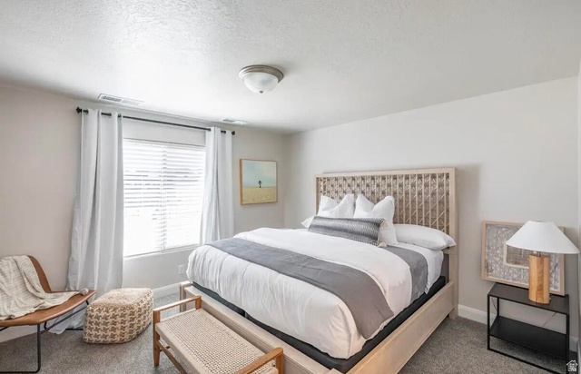 4846 Fishers Is Way St. George, UT 84770 - Photo 8 of 13 Bedroom featuring a light-toned wood-frame bed with an open geometric headboard