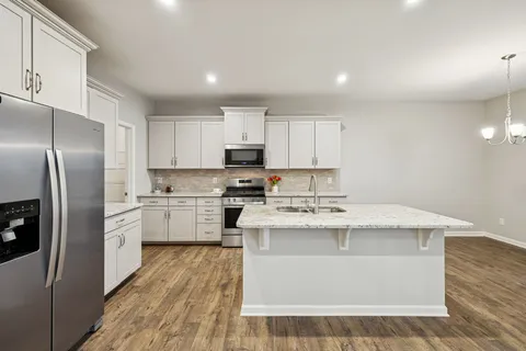 a kitchen with a stove a sink and a refrigerator