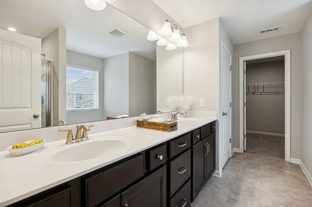 a bathroom with a granite countertop sink double vanity and a mirror