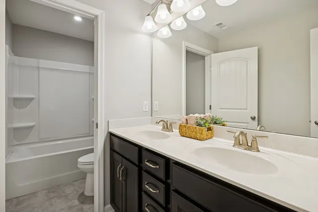 a bathroom with a granite countertop sink a toilet and bathtub
