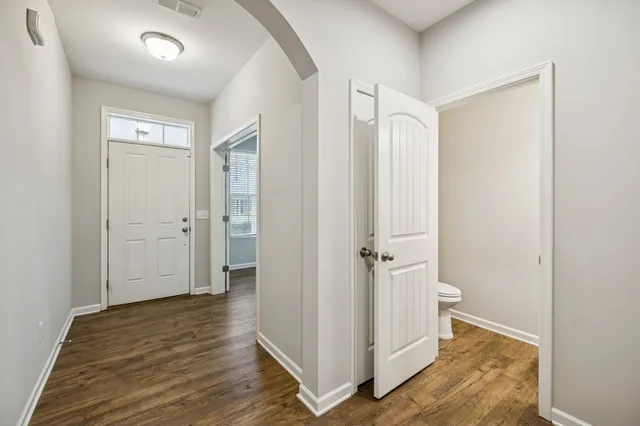 a view of a hallway with wooden floor and closet area