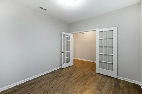an empty room with wooden floor and windows