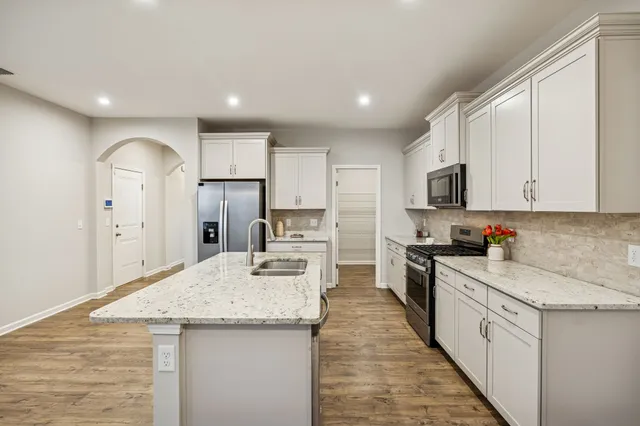 a kitchen with granite countertop white cabinets and white appliances