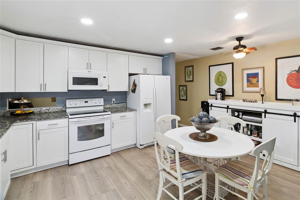 4191 Corey Road Malabar, FL 32950 - Photo 14 of 53 a open kitchen with stainless steel appliances kitchen island granite countertop a white table and chairs