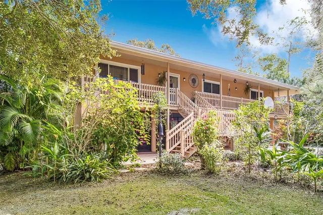 a view of a house with a yard and tree