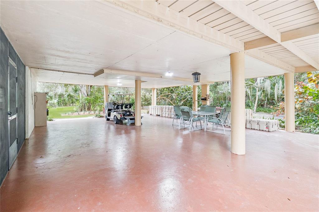 4191 Corey Road Malabar, FL 32950 - Photo 31 of 53 a view of a patio with table and chairs potted plants with floor to ceiling window