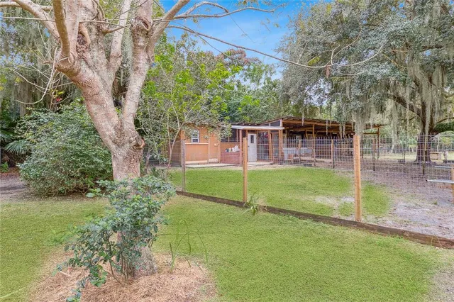 a front view of a house with a yard and a tree