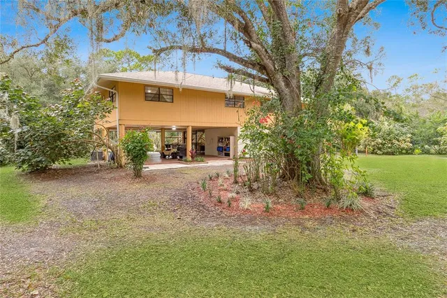 an aerial view of residential houses with outdoor space and trees