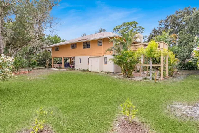 a view of a yard with plants and trees