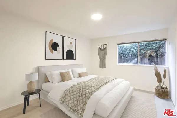 a bedroom with a bed and a painting on the wall