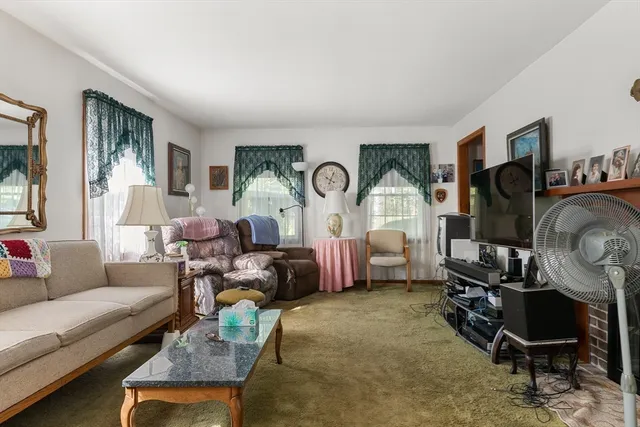 a living room with furniture fireplace and a window