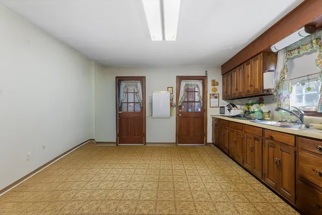 a view of kitchen with refrigerator and window