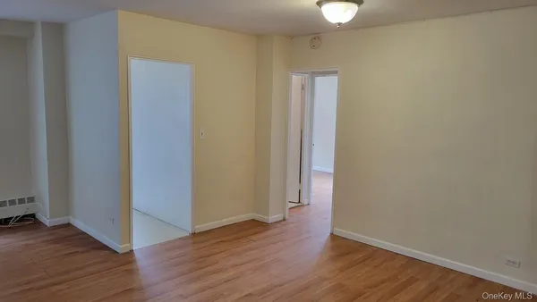 a view of an empty room with wooden floor