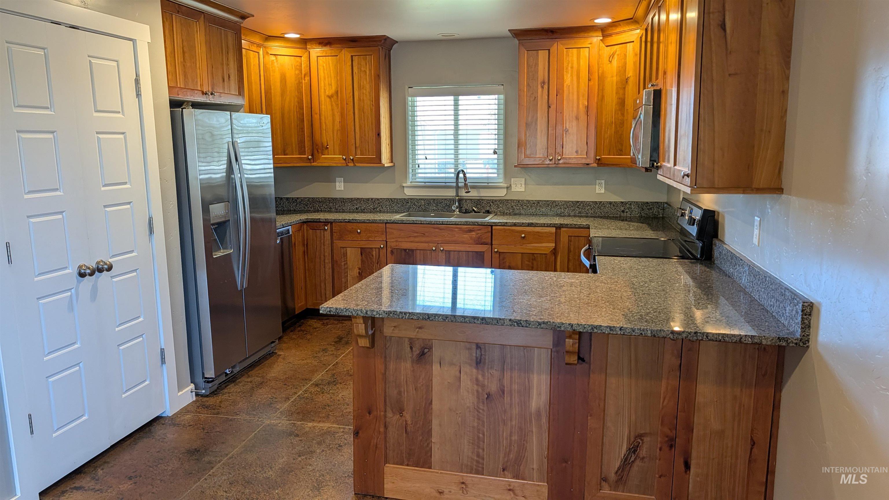 622 Lochsa Loop Heyburn, ID 83336 - Photo 2 of 17 Kitchen featuring wood cabinetry with recessed panel doors, stainless steel appliances, and stone countertops
