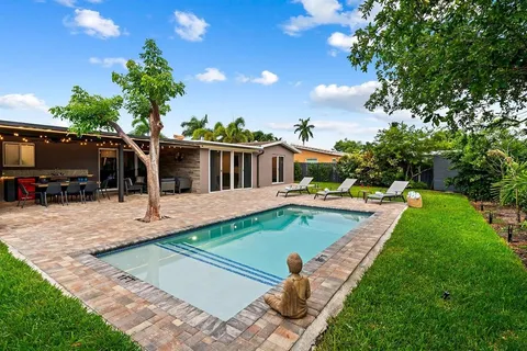 a view of a house with backyard and sitting area