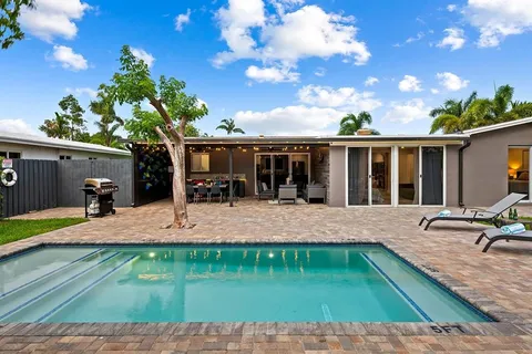 a view of a house with backyard and sitting area