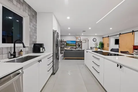 a large white kitchen with cabinets and stainless steel appliances