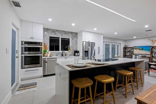 a large white kitchen with cabinets and stainless steel appliances