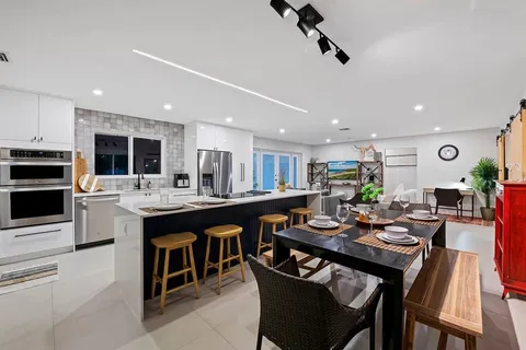 a kitchen with a dining table chairs and stove