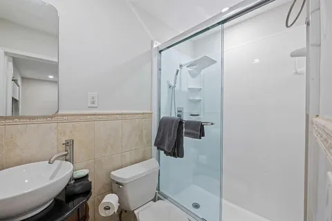 a bathroom with a toilet a sink and shower