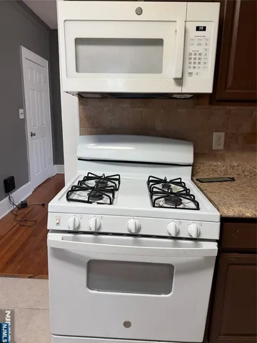 a stove top oven sitting inside of a kitchen