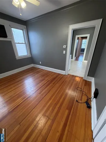 a view of empty room with window and wooden floor