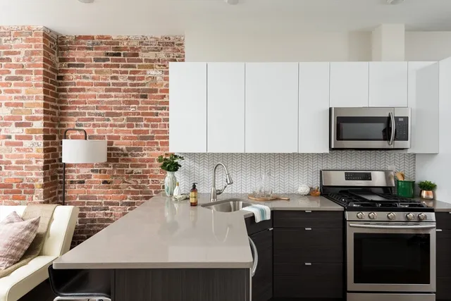 a kitchen with stainless steel appliances a stove a sink a microwave a refrigerator and cabinets