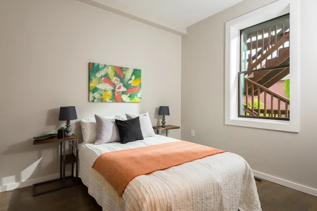 a bed sitting in a bedroom next to a window